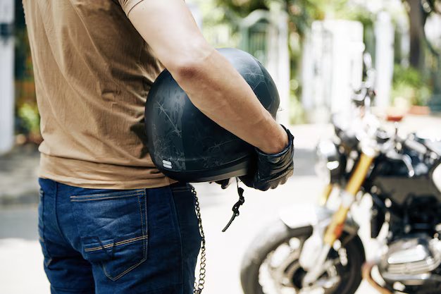 hombre-casco-manos-mirando-su-motocicleta-enfoque-selectivo-274689-26673