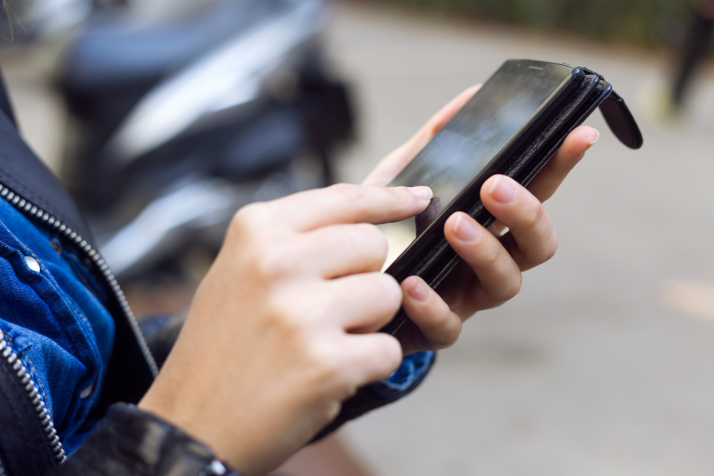 joven-bella-mujer-utilizando-su-telefono-movil-calle