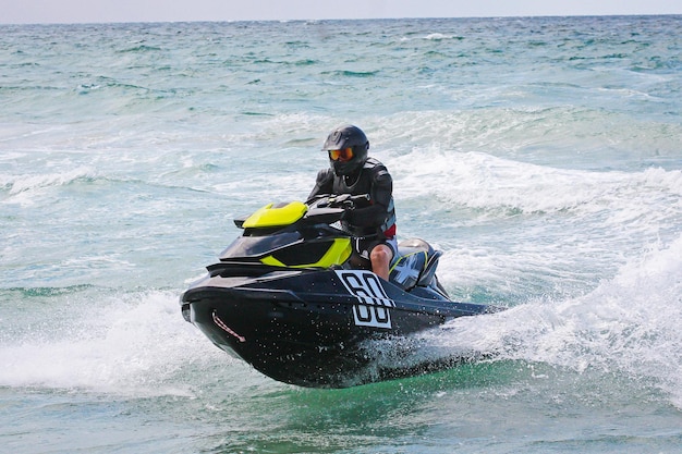 Moto de agua Joven en moto de agua Piloto de moto de agua profesional Campeonato de moto de agua Moto de agua realiza muchos trucos sobre las olas | Foto Premium
